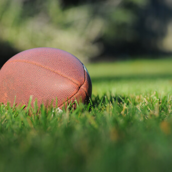a football lies in a field of grass